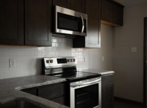 a kitchen with stainless steel appliances and black cabinets.
