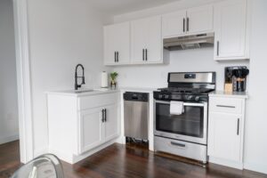a small kitchen with white cabinets and stainless steel appliances.