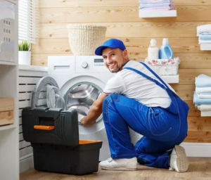 a man fixing a washing machine in a room.