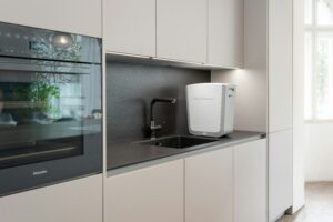 A kitchen with white cabinets and a white refrigerator.