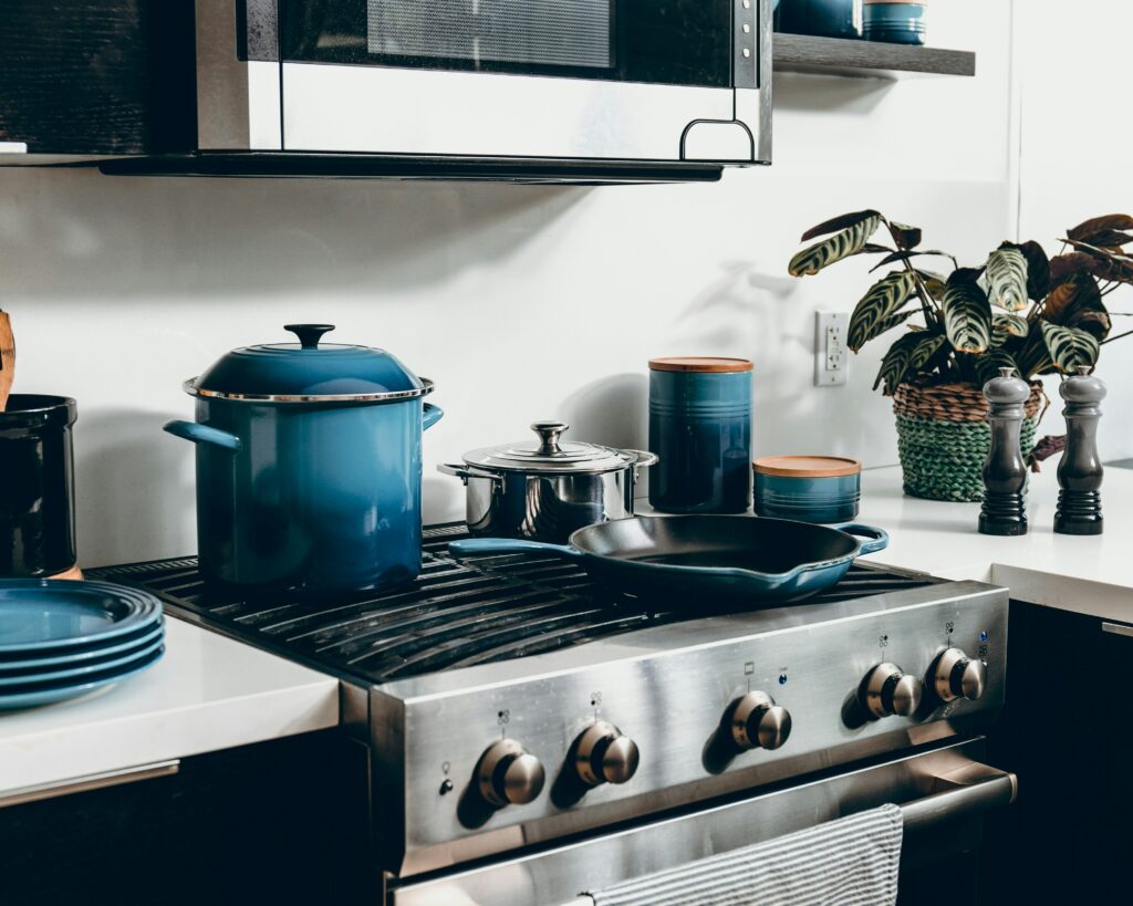 A kitchen with blue pots and pans on the stove.
