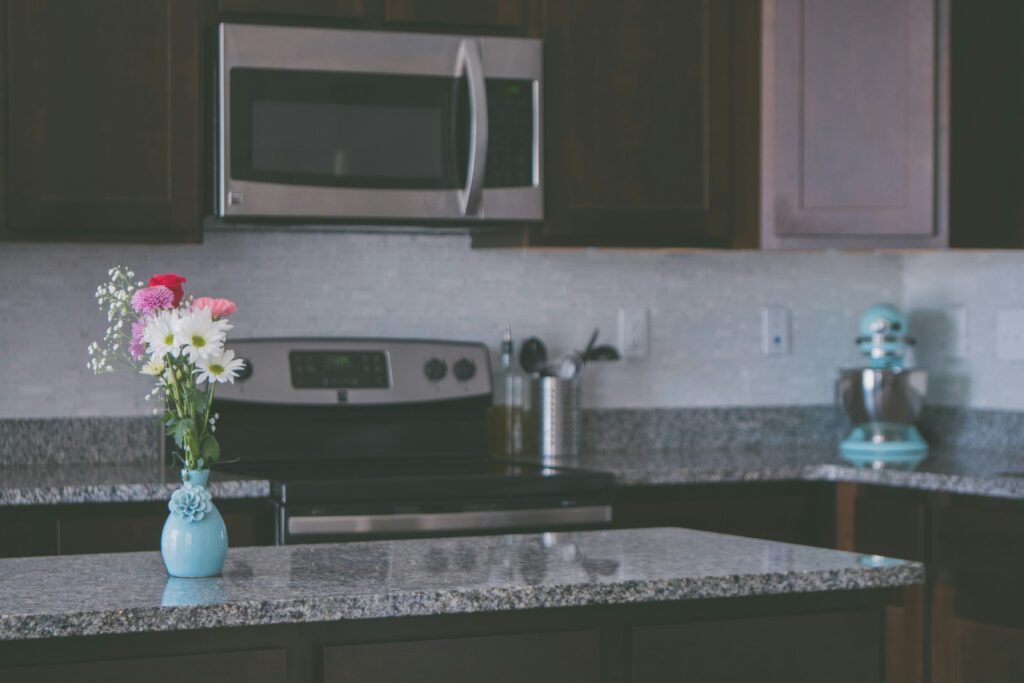 A kitchen counter with a vase of flowers.