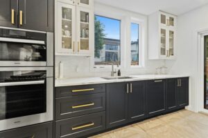 A black and gold kitchen with a door to the outside.