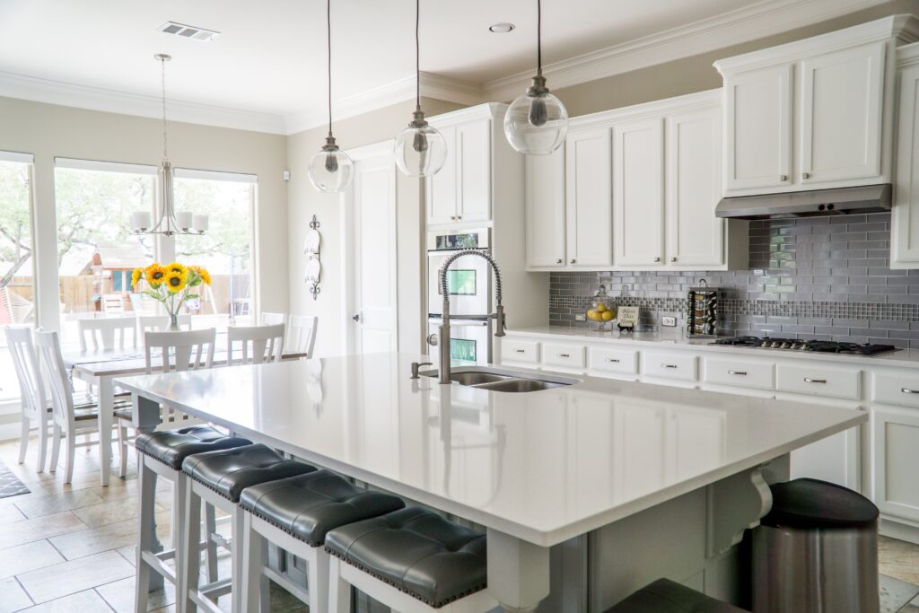 A white kitchen with a center island and stools.
