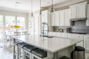 A white kitchen with a center island and stools.