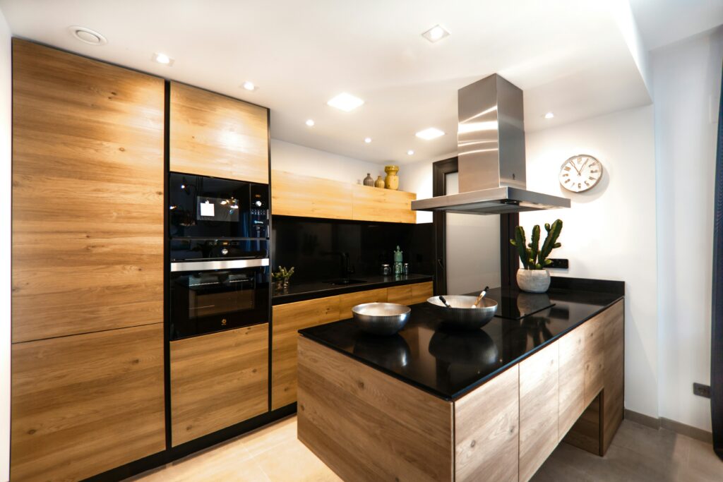 A kitchen with black counter tops and wooden cabinets.