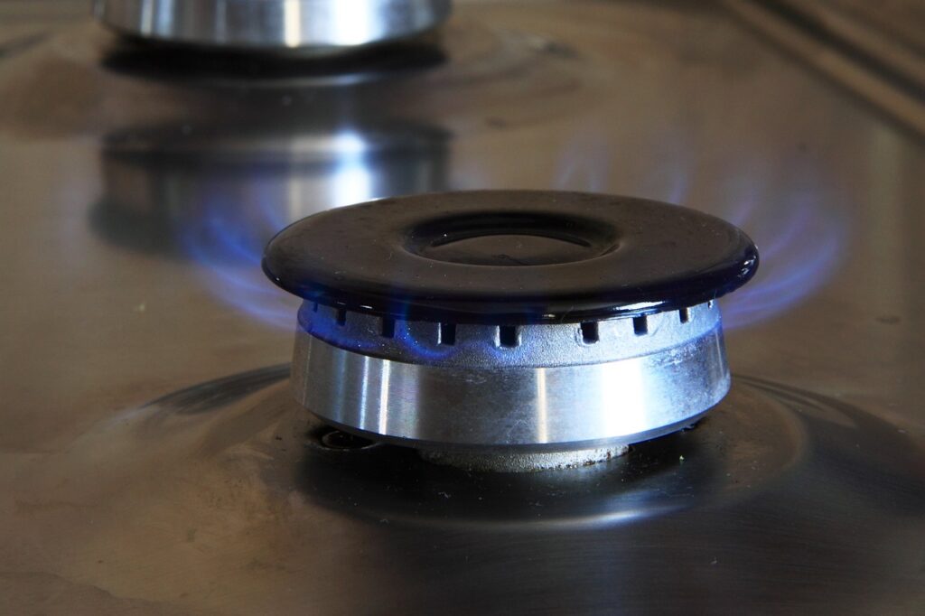 A close up of a gas stove with blue flames.