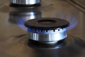 A close up of a gas stove with blue flames.