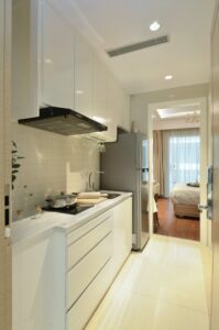 A white kitchen with stainless steel appliances and white cabinets.