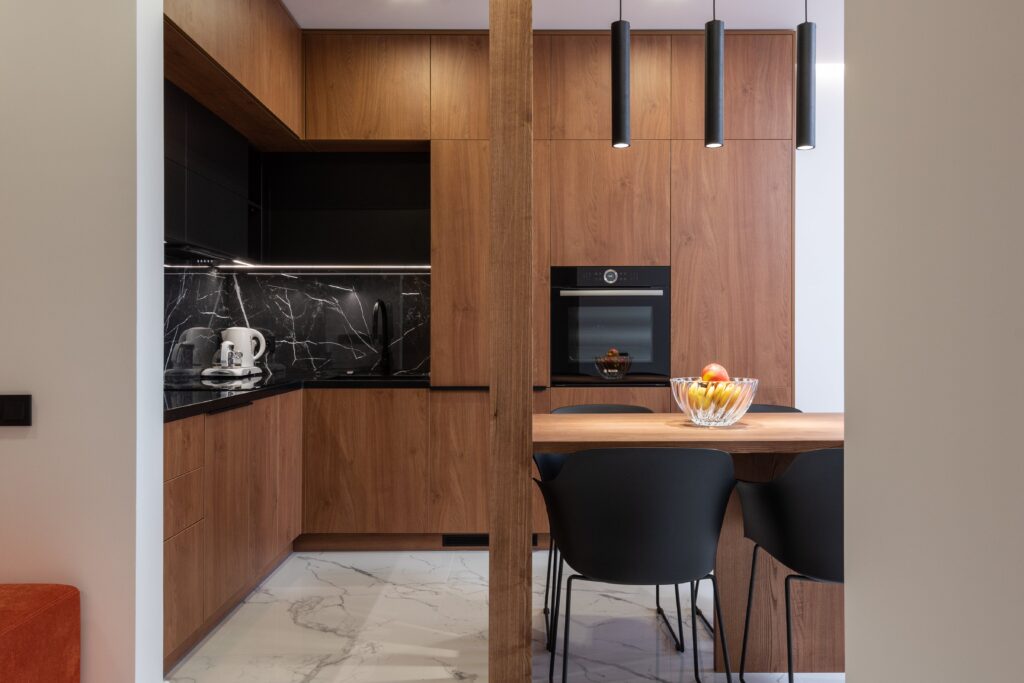 A modern kitchen with wooden cabinets and marble counter tops.