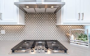 A kitchen with stainless steel appliances and white cabinets.