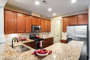 A kitchen with granite counter tops and stainless steel appliances.