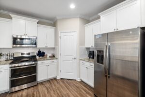A kitchen with white cabinets and stainless steel appliances.