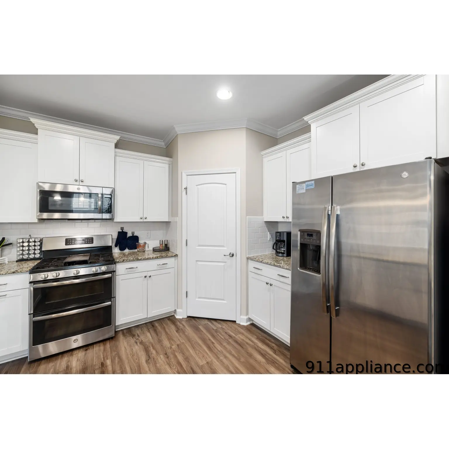 Modern white kitchen with stainless steel appliances