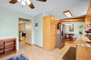 A kitchen with a ceiling fan and a refrigerator.