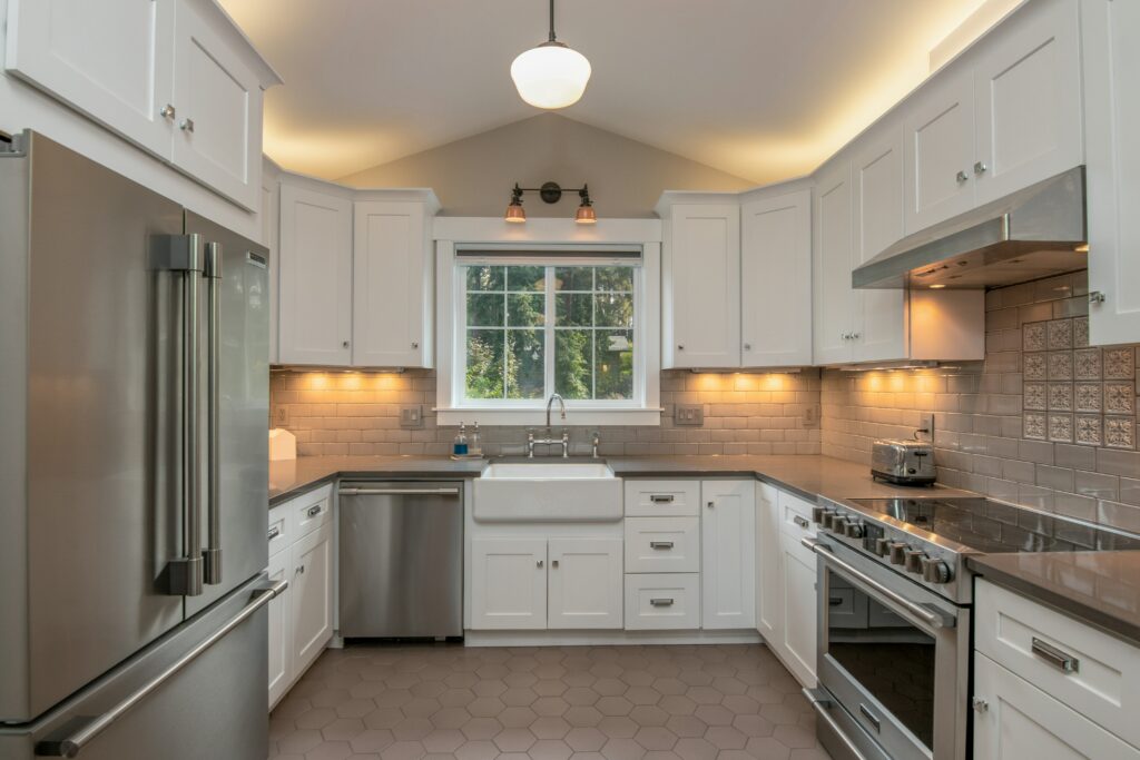 A kitchen with white cabinets and stainless steel appliances.