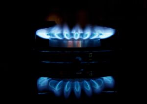 A gas stove with blue flames in the dark.