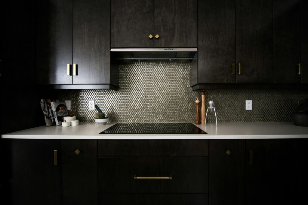A kitchen with black cabinets and gold accents.