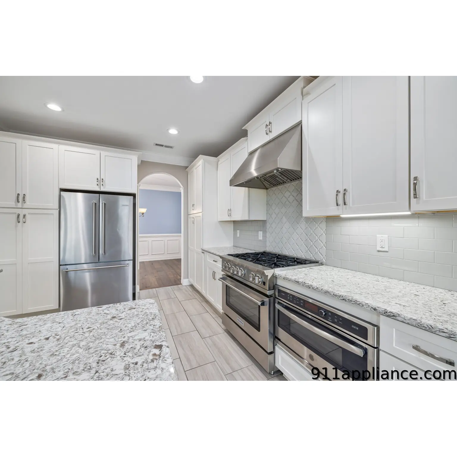 Modern white kitchen with stainless steel appliances