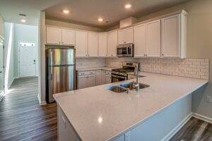 A kitchen with white cabinets and stainless steel appliances.