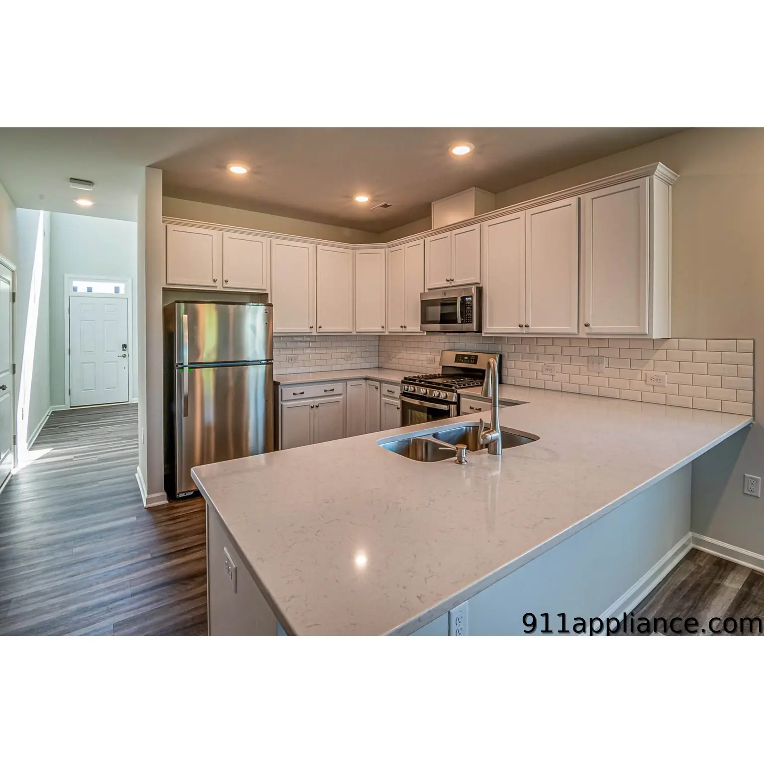 Modern white kitchen with stainless steel appliances