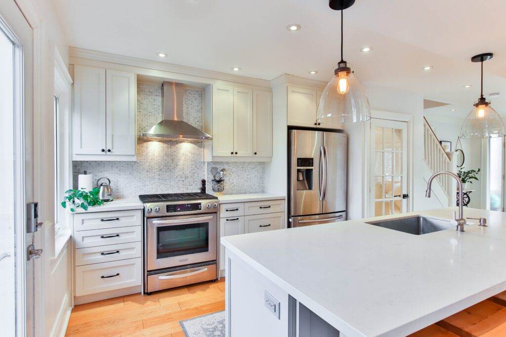 A white kitchen with stainless steel appliances.