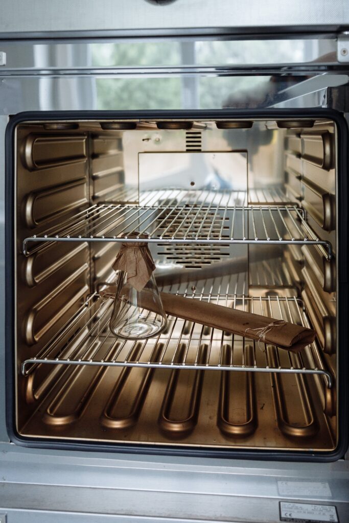 a stainless steel oven with a wooden spatula in it.