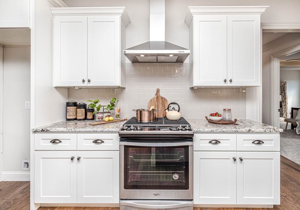 a white kitchen with a stove and oven.