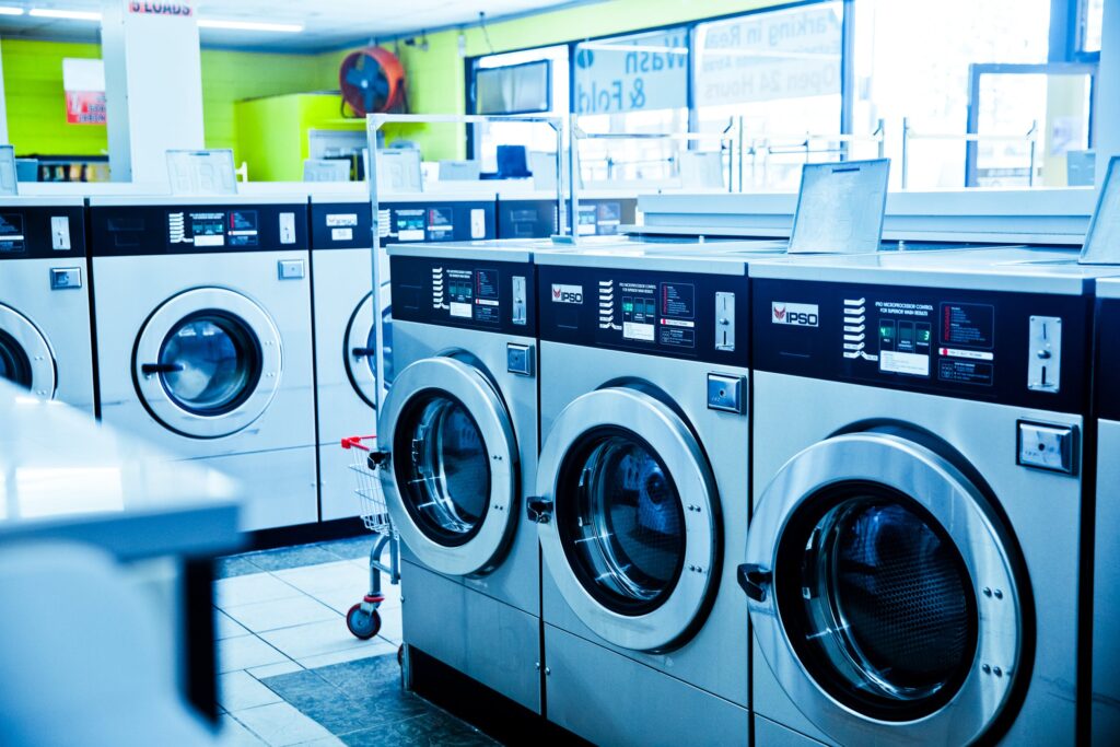 a row of washers and dryers in a laundry room.