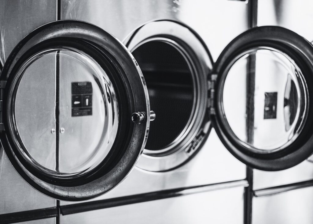 a row of washers and dryers in a laundry room.