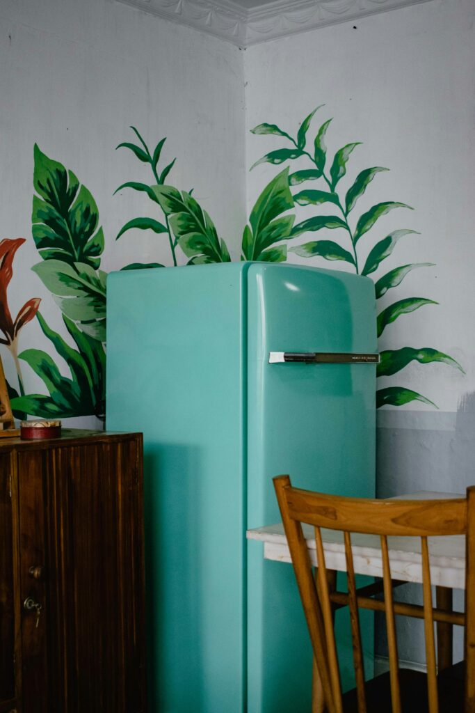 a small kitchen with a refrigerator and a table.