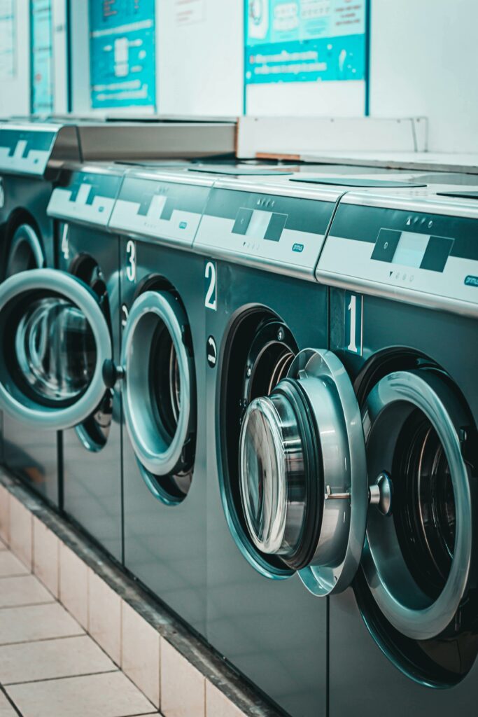 a row of washing machines in a laundry room.