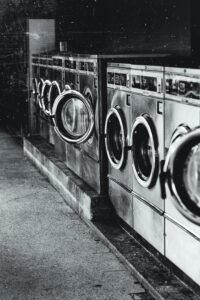 Black and white photo of a row of washing machines.