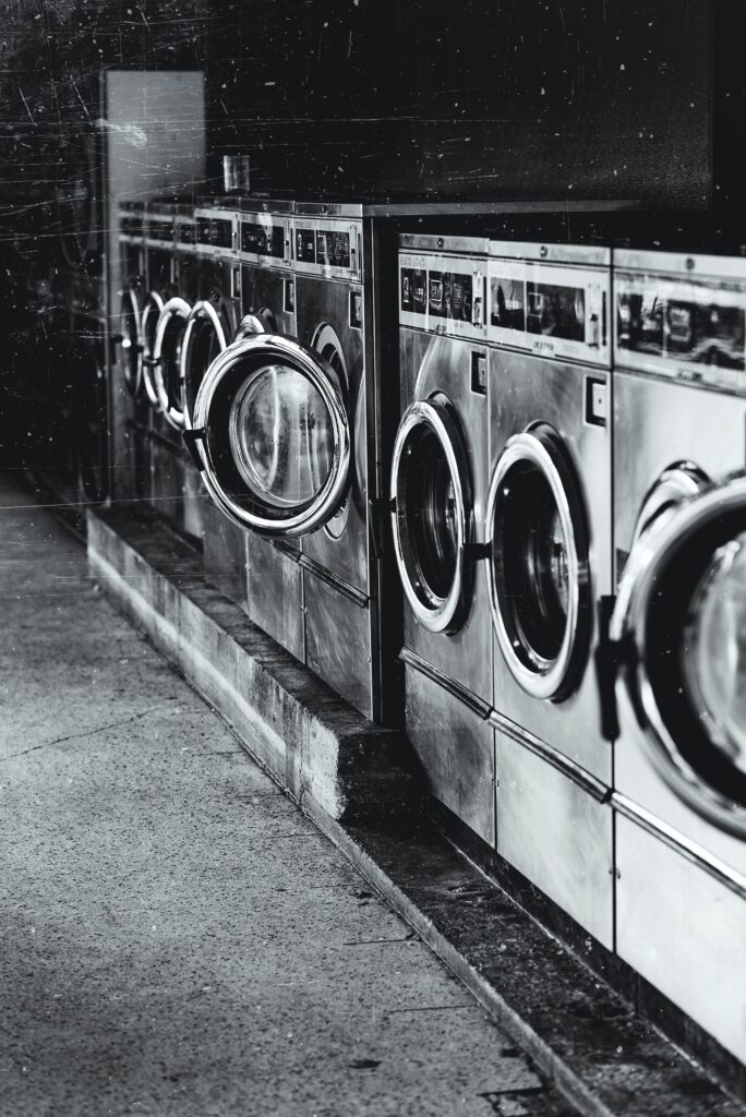 Black and white photo of a row of washing machines.