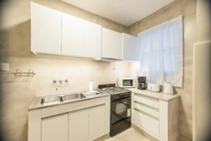 A small kitchen with white cabinets and a microwave.