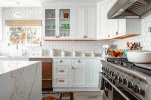 A kitchen with white cabinets and a stove.
