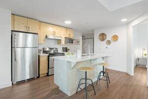 A kitchen with stainless steel appliances and wood floors.