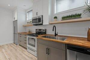 A kitchen with wood counter tops and stainless steel appliances.
