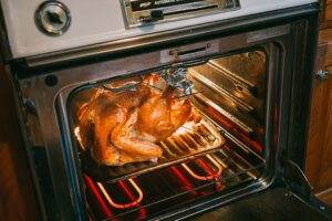 A turkey is cooking in an oven.