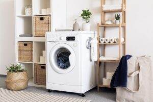 A laundry room with a washing machine and baskets.