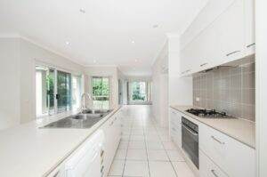 A white kitchen with a sink and a dishwasher.