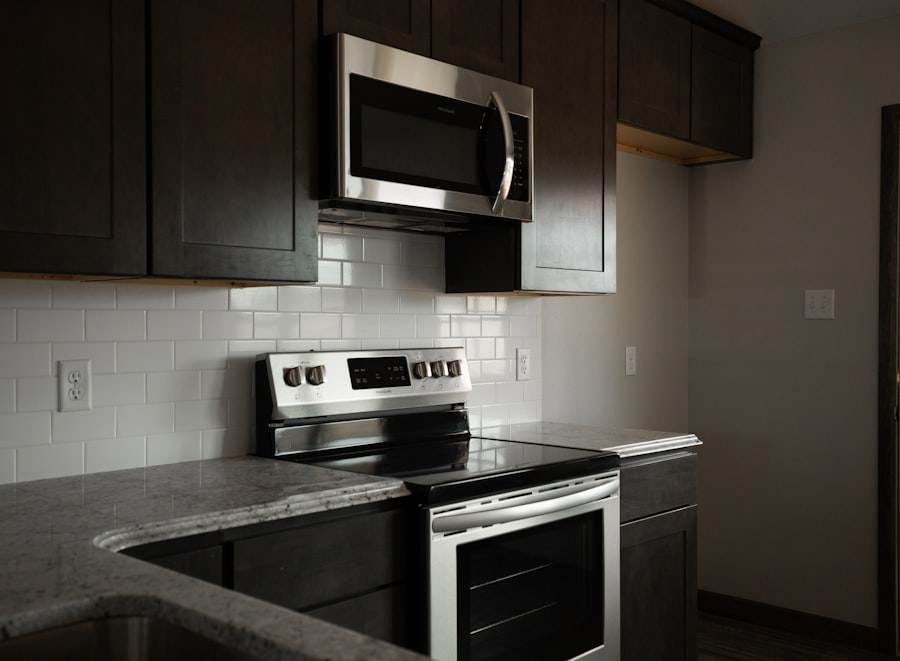 A kitchen with stainless steel appliances and black cabinets.