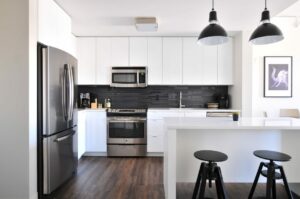 a kitchen with black and white cabinets and stools.