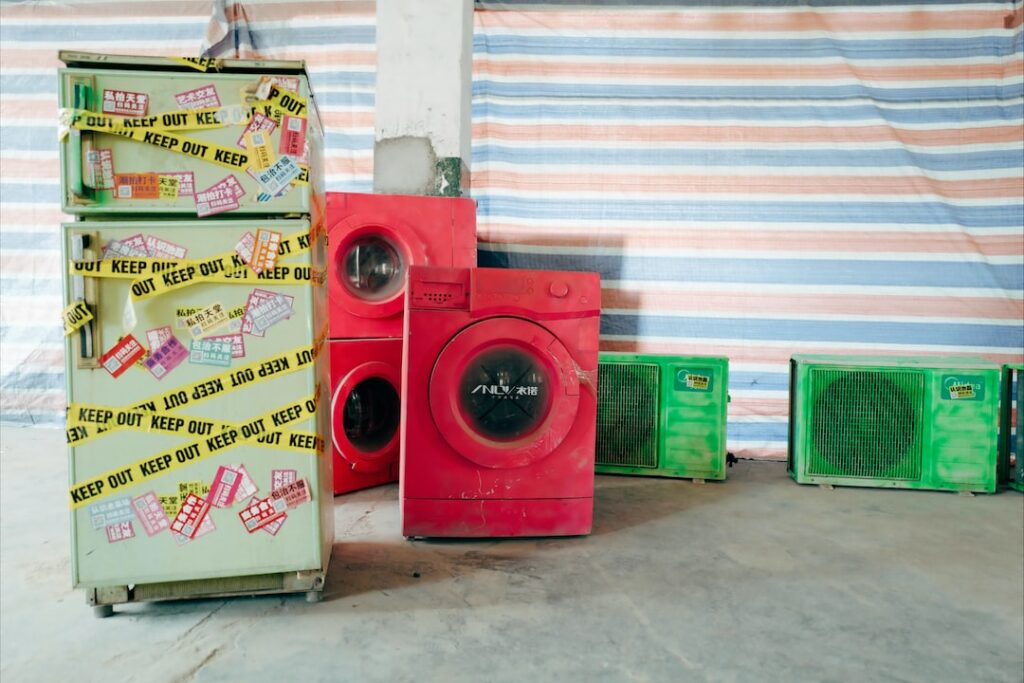 a group of old washing machines in a room.