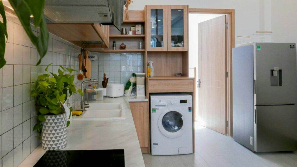 A small kitchen with a washing machine and refrigerator.