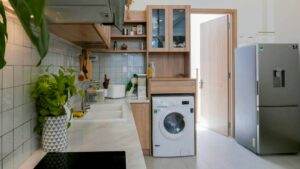A small kitchen with a washing machine and refrigerator.
