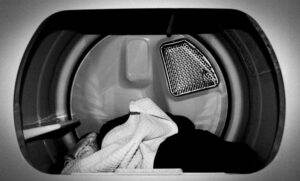 Interior of a clothes dryer with clothes inside, highlighting affordable appliance repair services.