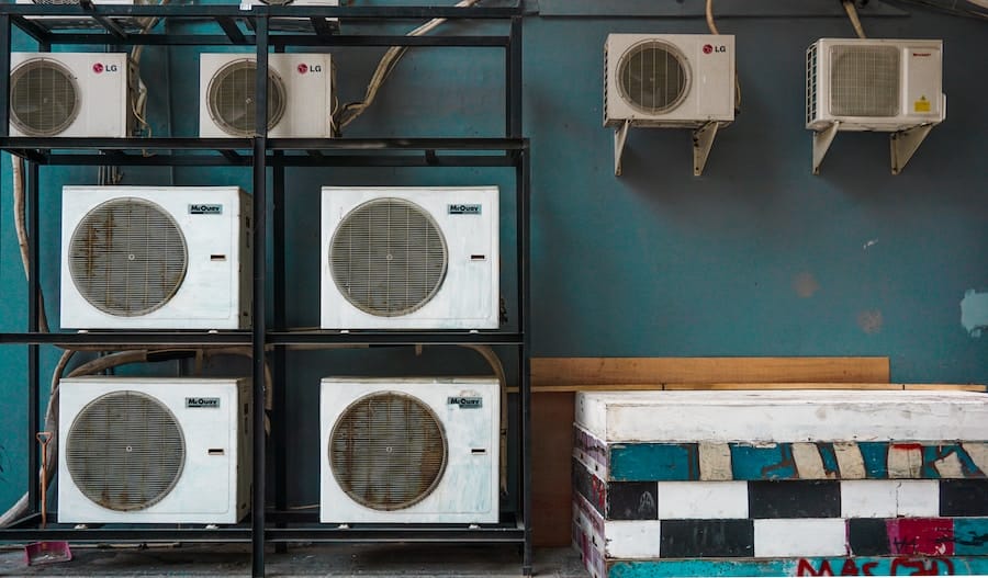 a group of white air conditioners on a shelf.