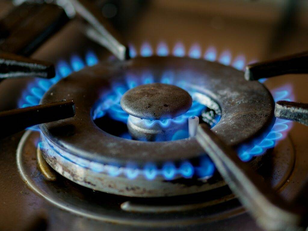 A close up of a gas stove with blue flames is essential for a complete guide on home appliances.