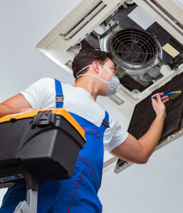 a man working on an air conditioning unit.